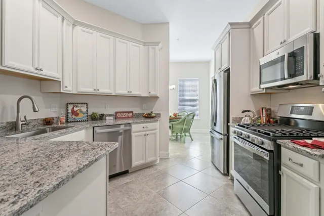 a kitchen with granite countertop a stove sink and microwave