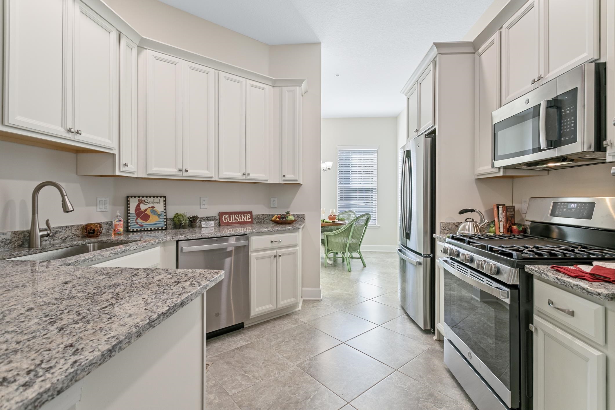 a kitchen with granite countertop a stove sink and microwave