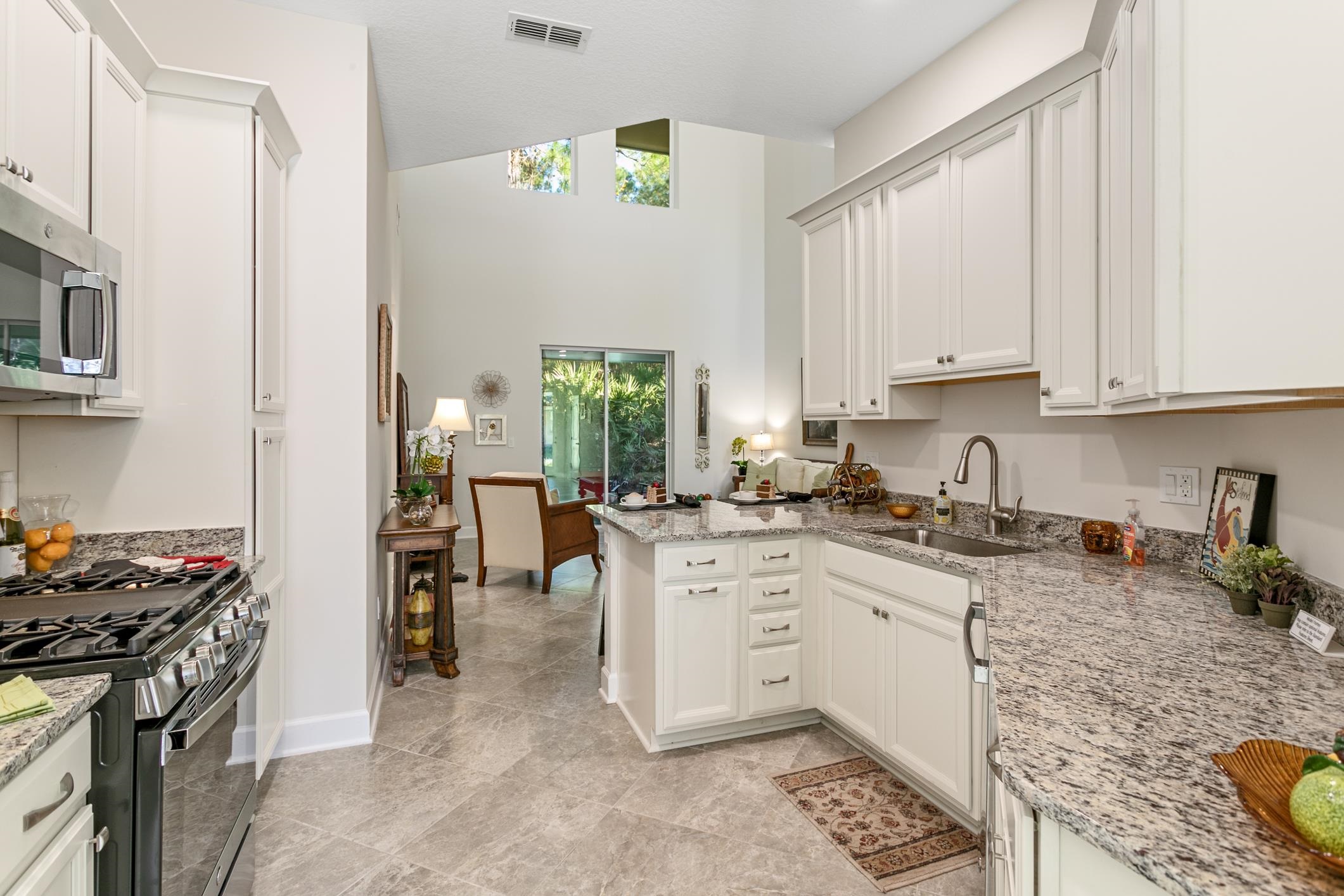 264 Grand Ravine Drive St. Augustine, FL 32086 - Photo 11 of 46 a kitchen with stainless steel appliances granite countertop a stove top oven a sink a counter space and cabinets
