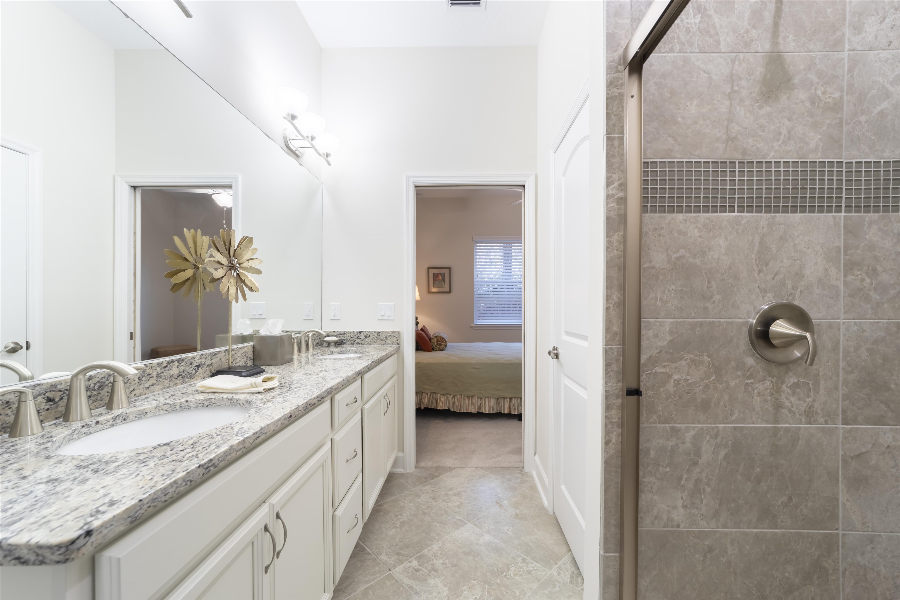 264 Grand Ravine Drive St. Augustine, FL 32086 - Photo 24 of 46 a en suite bathroom with a granite countertop double vanity sink a mirror and a shower
