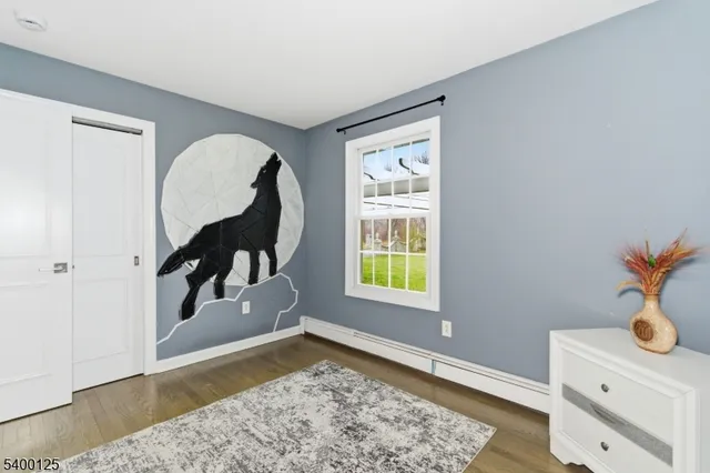 a view of a bedroom with wooden floor and a window