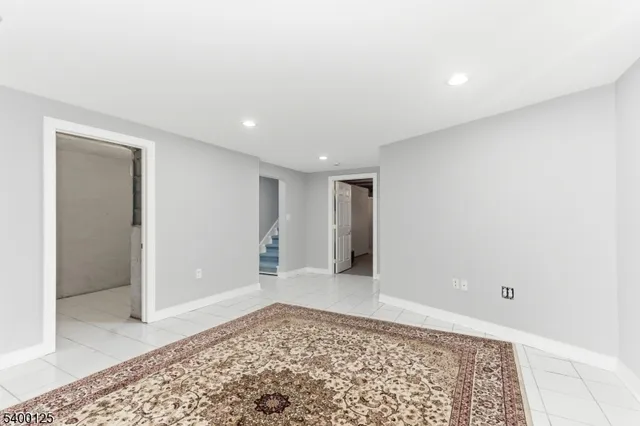a view of a big room with a rug and a window