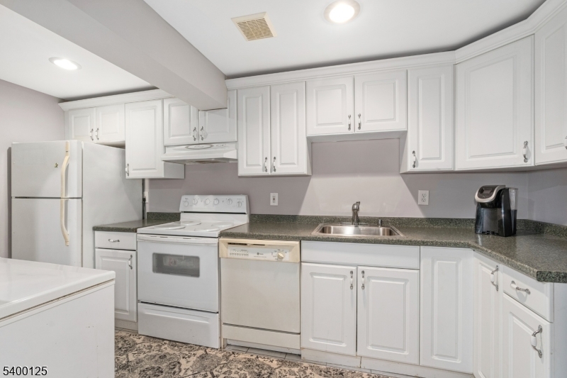 18 Old Wolfe Road Budd Lake, NJ 07828 - Photo 28 of 49 a kitchen with granite countertop white cabinets and white appliances