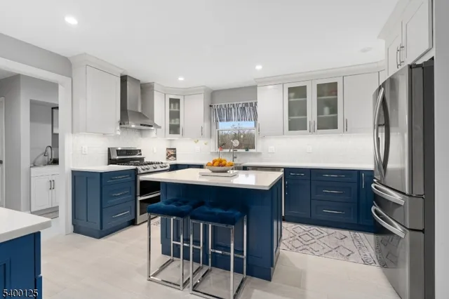 a kitchen with stainless steel appliances granite countertop a refrigerator a sink dishwasher a stove with wooden cabinets and floor