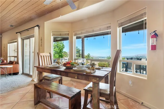 a dining room with furniture large windows and wooden floor