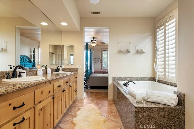 a spacious bathroom with sinks mirror and a bathtub