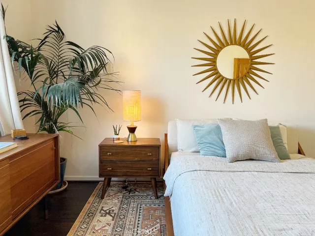 a bedroom with a bed and a potted plant