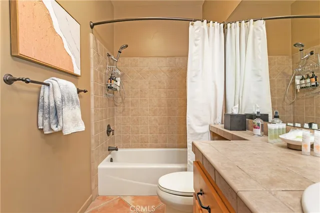 a bathroom with a granite countertop sink a toilet and shower