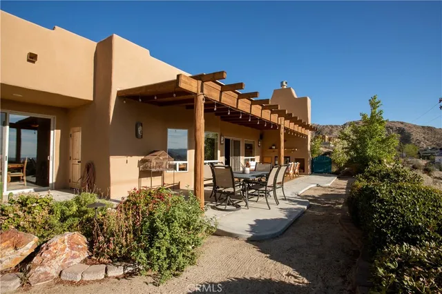 a view of a patio with table and chairs and potted plants