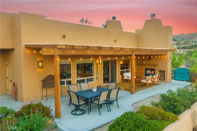 a view of a patio with couches table and chairs and potted plants