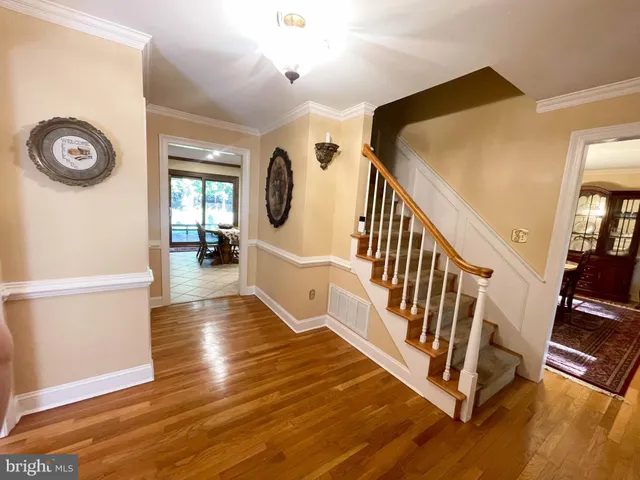 a living room with furniture a flat screen tv and a refrigerator