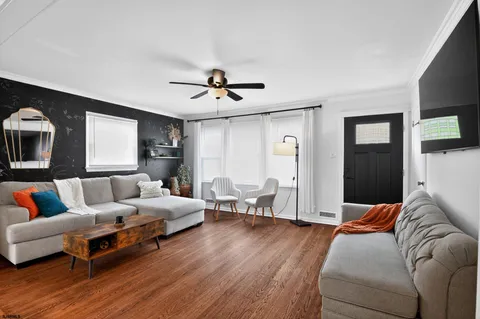 a living room with furniture and a wooden floor
