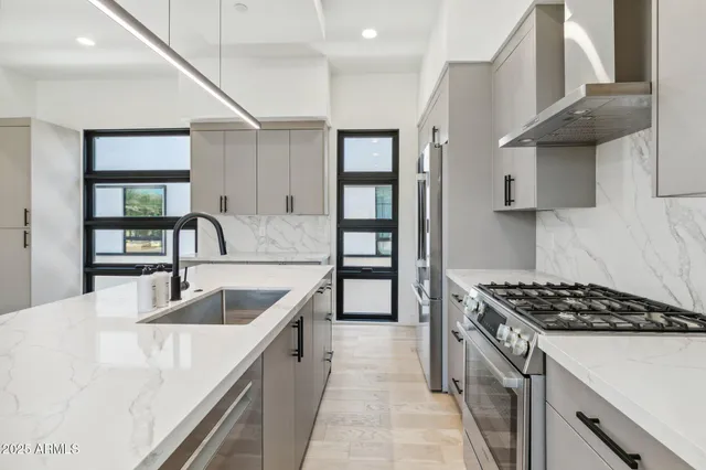 a kitchen with stainless steel appliances granite countertop a sink stove and cabinets