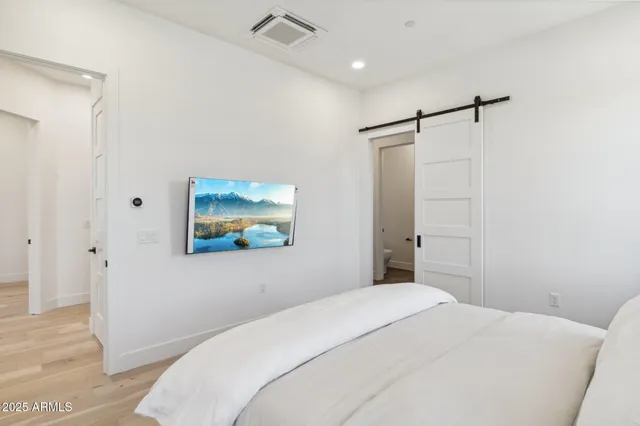a bedroom with a bed and a painting on the wall