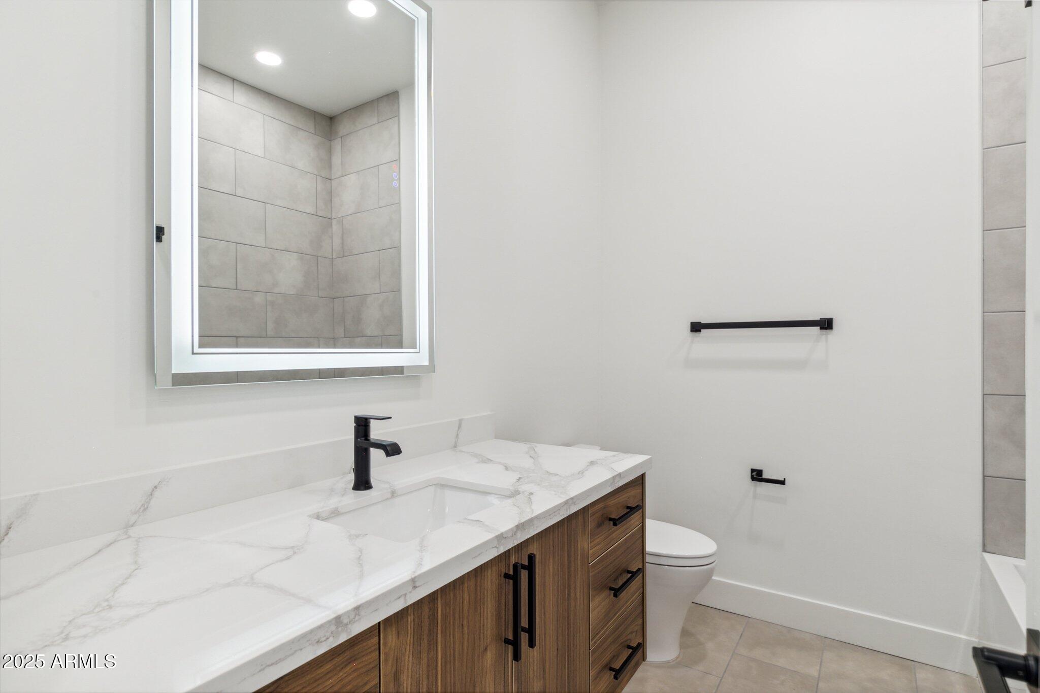 1501 North Miller Road, Unit 1016 Scottsdale, AZ 85257 - Photo 18 of 23 a bathroom with a granite countertop sink and a toilet