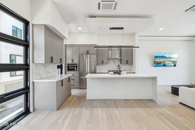 a large white kitchen with a sink stainless steel appliances and cabinets