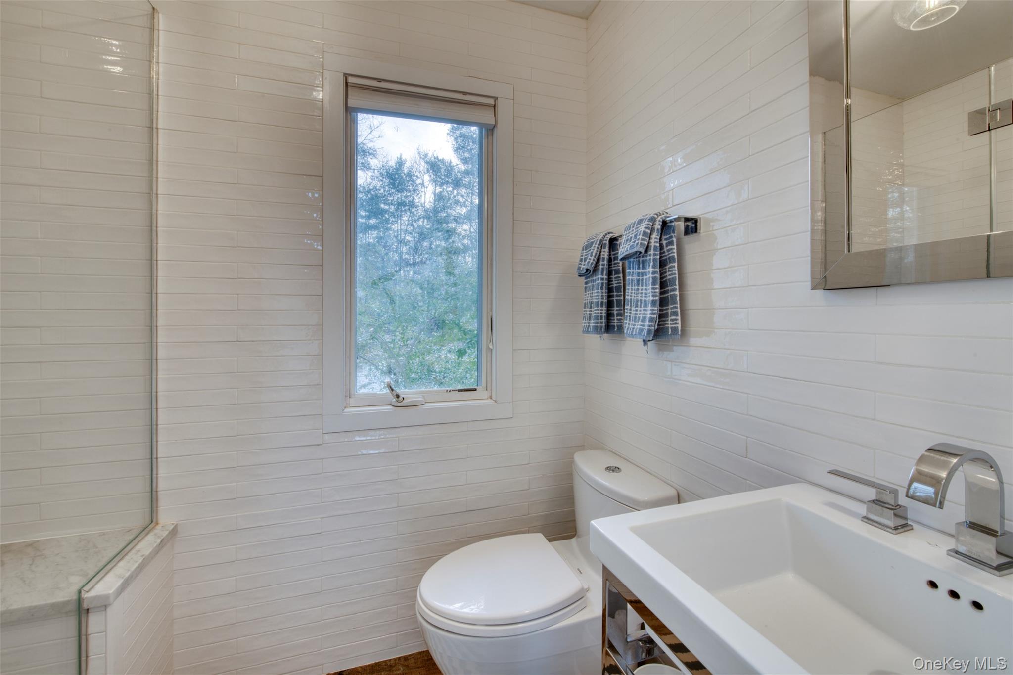 57 Big Fresh Pond Road Southampton, NY 11968 - Photo 15 of 18 a bathroom with a sink a toilet and a mirror