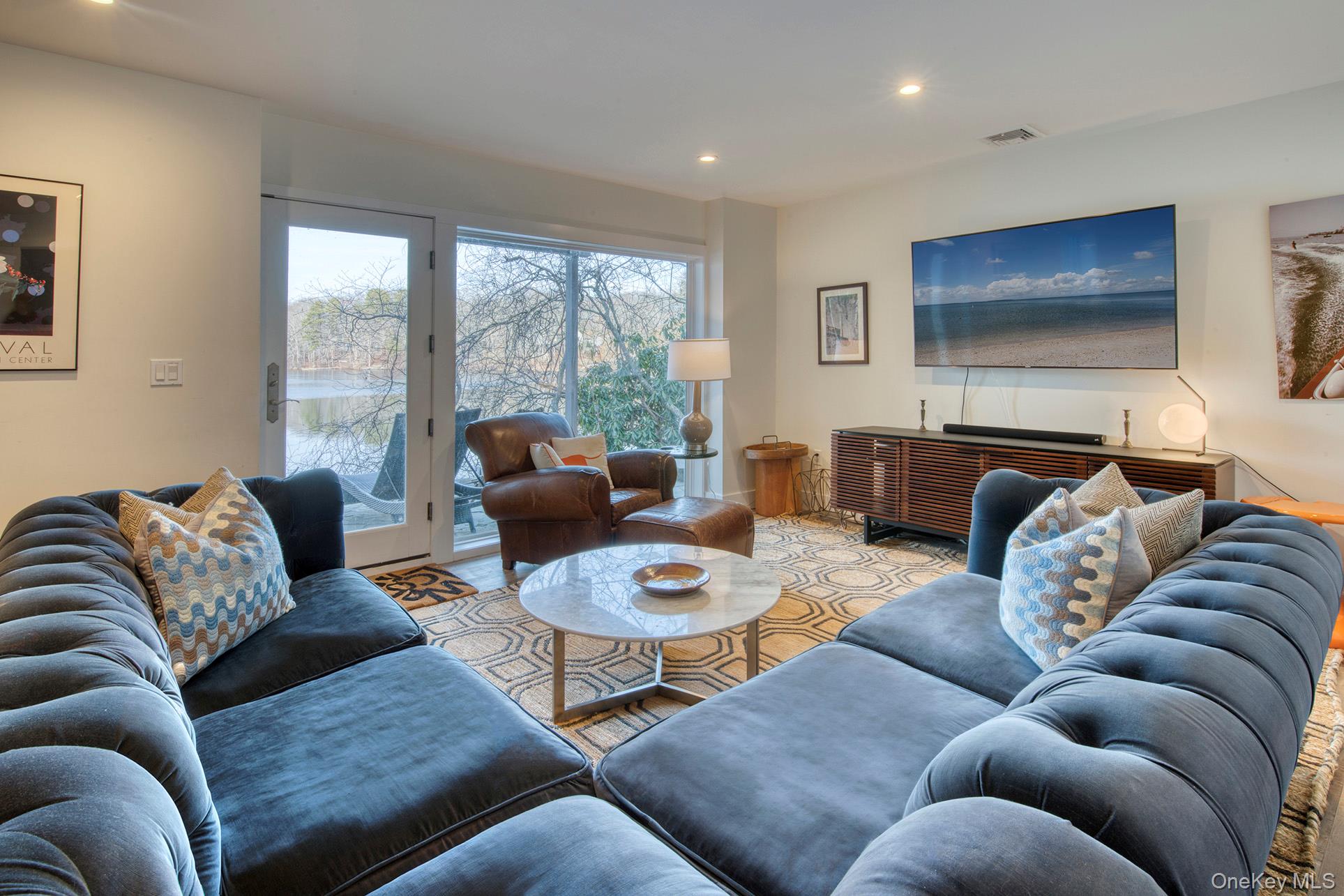 57 Big Fresh Pond Road Southampton, NY 11968 - Photo 6 of 18 a living room with furniture a flat screen tv and a large window