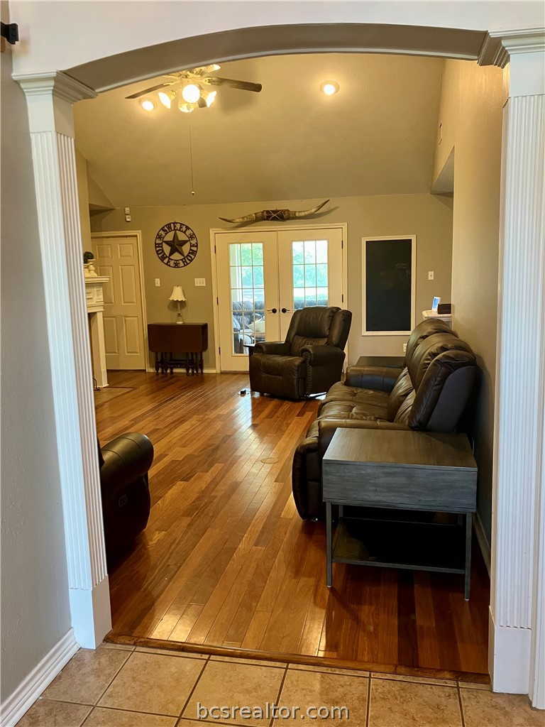 5660 Falling Water Bryan, TX 77808 - Photo 20 of 27 Living room featuring light wood-type flooring, vaulted ceiling, ceiling fan, and ornate columns