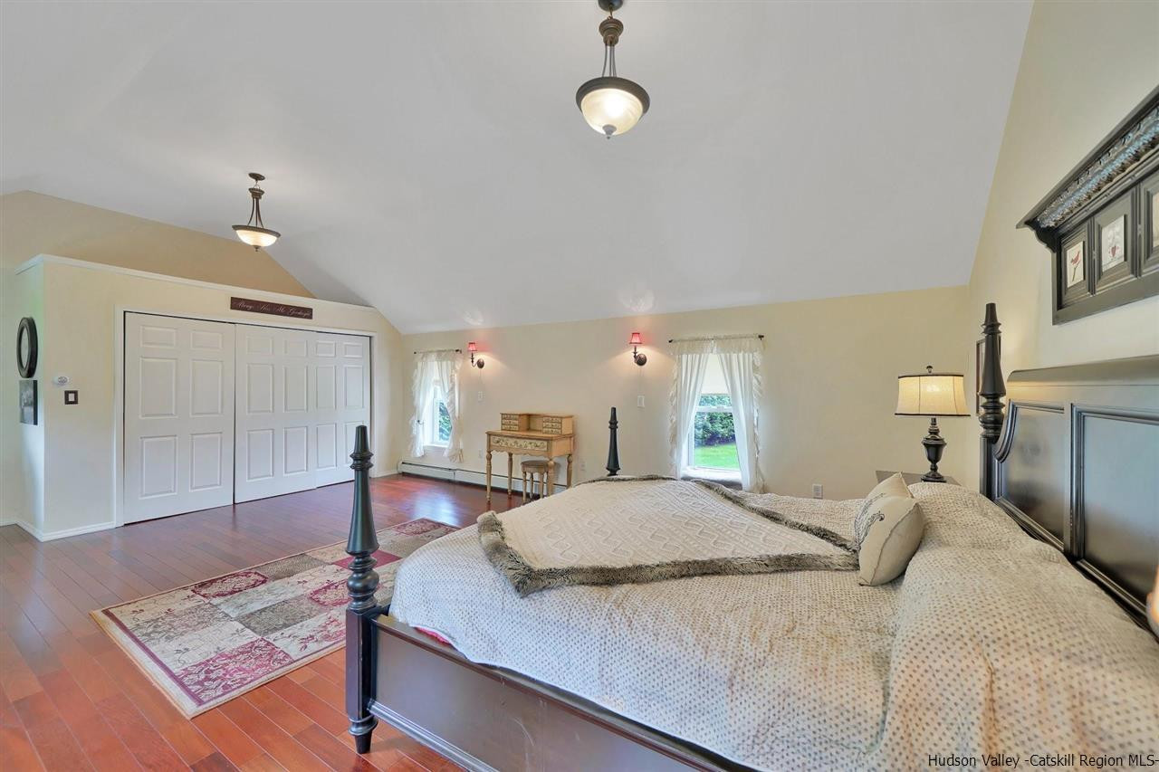 78 E Road Wallkill, NY 12589 - Photo 20 of 27 a spacious bedroom with a bed and a chandelier