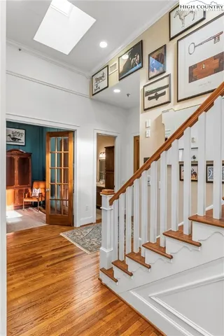 a view of a hallway with wooden floor and windows