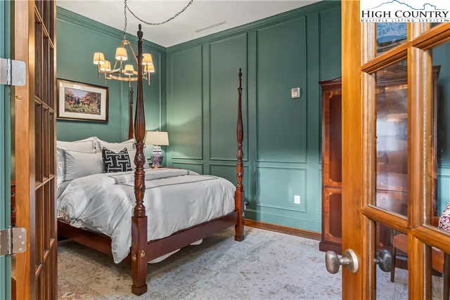 a spacious bedroom with a bed and a chandelier