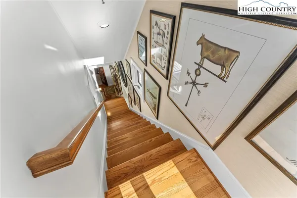 a view of staircase with lots of frames on wall and a window