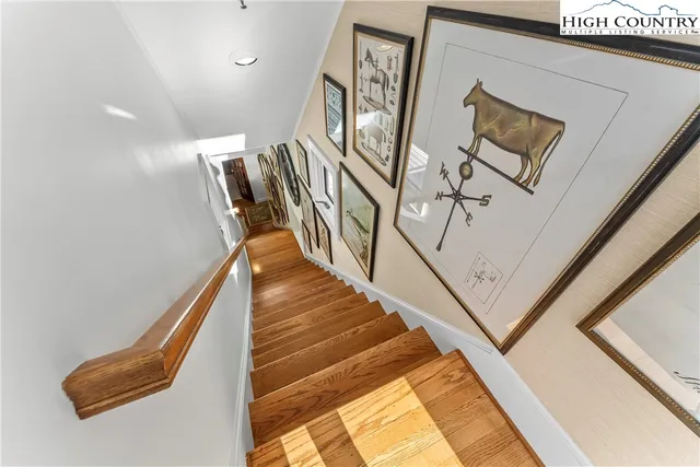 a view of staircase with lots of frames on wall and a window