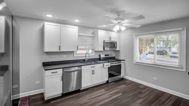 a kitchen with stainless steel appliances granite countertop a stove and a sink