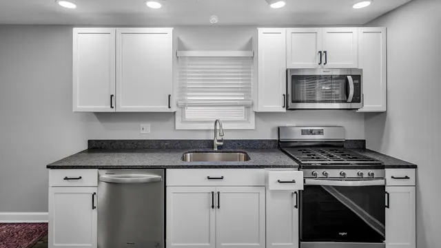 a kitchen with cabinets stainless steel appliances and a sink