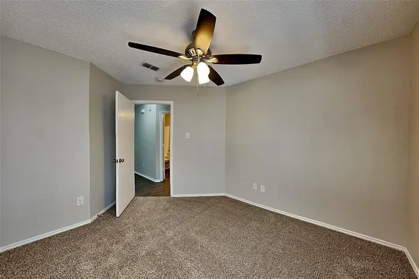 an empty room with closet and a chandelier fan