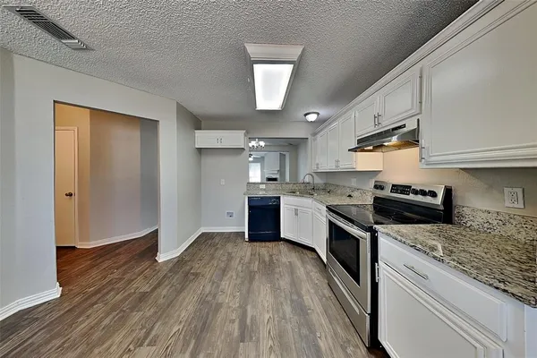 a kitchen with granite countertop a sink cabinets stainless steel appliances and a counter top space