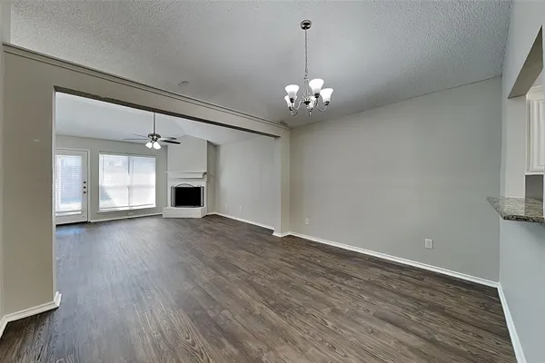 an empty room with wooden floor and ceiling fan