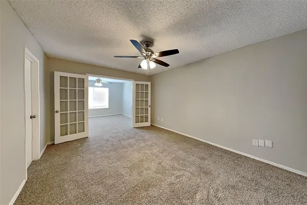 an empty room with closet and ceiling fan