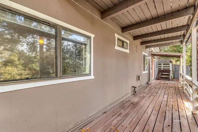 a view of a room with wooden floor fire place and windows