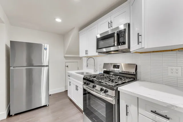 a view of staircase with white walls and white door