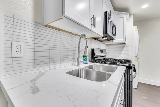 a view of a livingroom with wooden floor and a ceiling fan