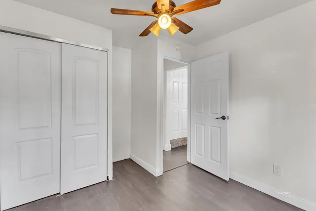 a view of empty room with wooden floor and window