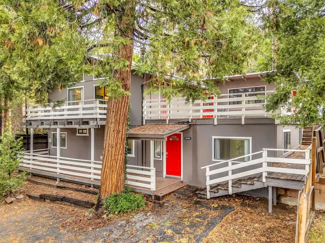 a front view of a house with a tree