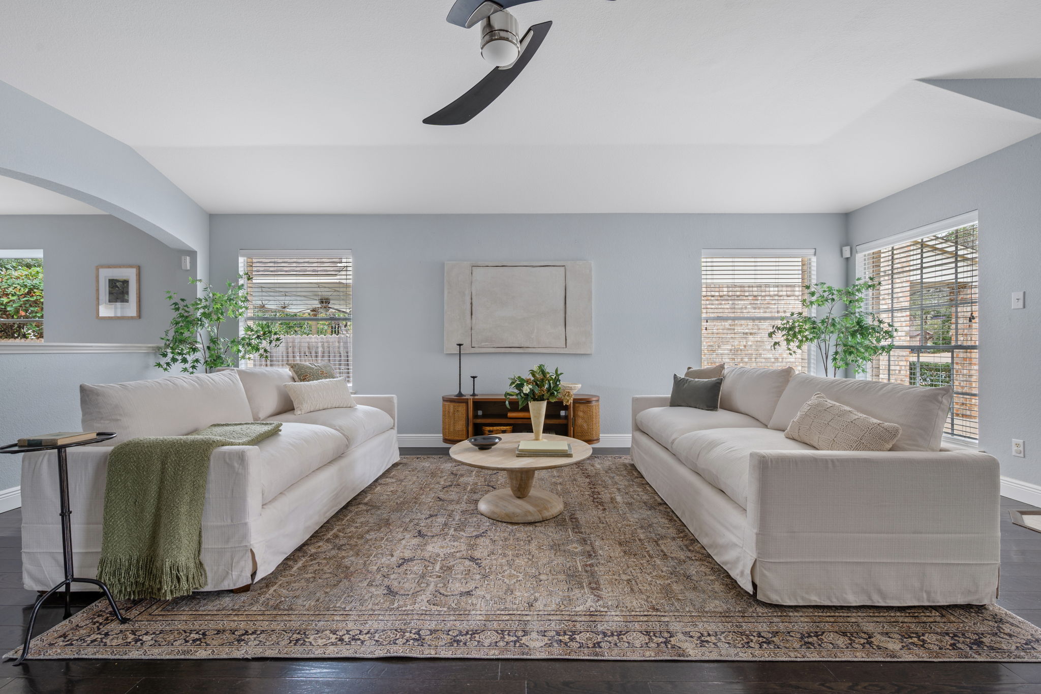 Living room featuring wood finished floors, ceiling fan, and lots of natural light.