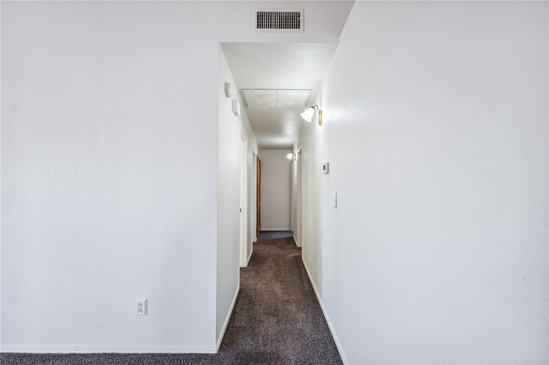 2524 South Ridge Avenue Bullhead City, AZ 86429 - Photo 35 of 64 Hall with dark carpet, baseboards, and attic access