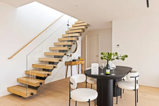 a kitchen with stainless steel appliances kitchen island granite countertop a table chairs in it and wooden floors