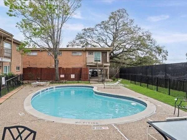 a view of a swimming pool with back yard of a house