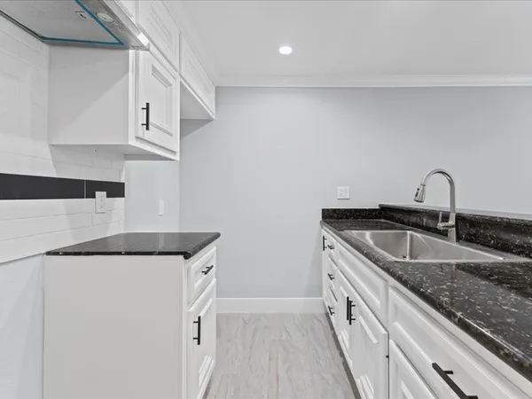 a kitchen with granite countertop a sink and cabinets