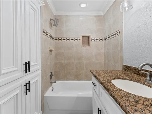 a bathroom with a granite countertop sink a mirror and a bathtub