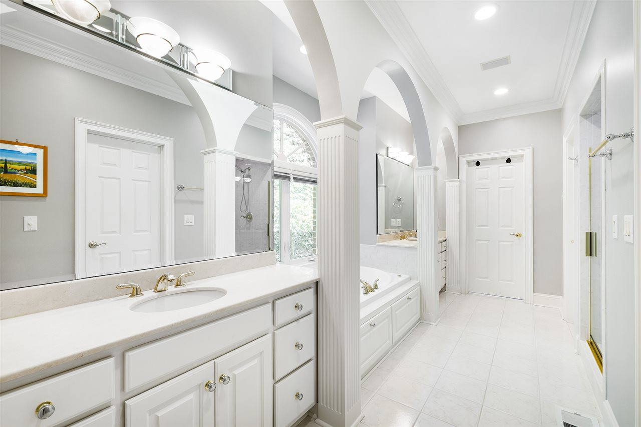 1102 Stonebridge Drive Durham, NC 27712 - Photo 15 of 30 a spacious bathroom with a double vanity sink a mirror and a bathtub