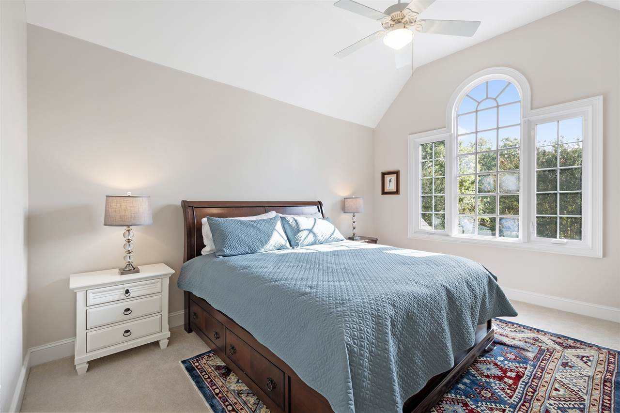 1102 Stonebridge Drive Durham, NC 27712 - Photo 20 of 30 a bedroom with a bed and a chandelier