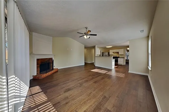 a view of a livingroom with wooden floor and a ceiling fan