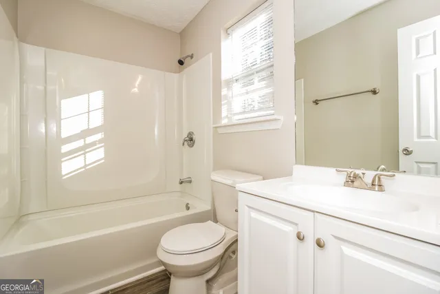 a bathroom with a sink toilet vanity and tub