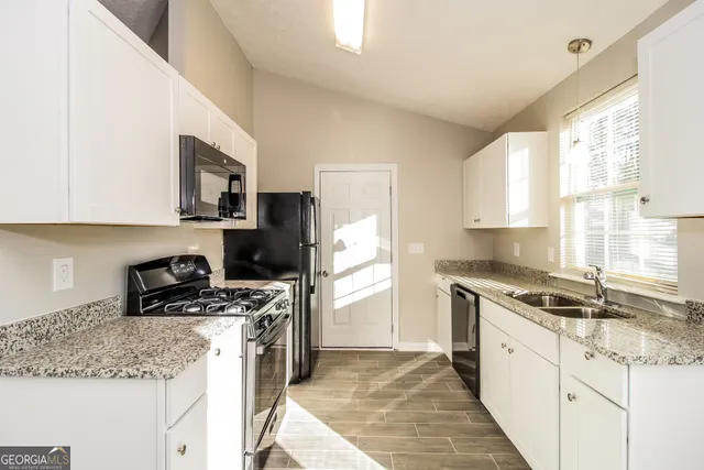 a kitchen with a stove a sink and a refrigerator